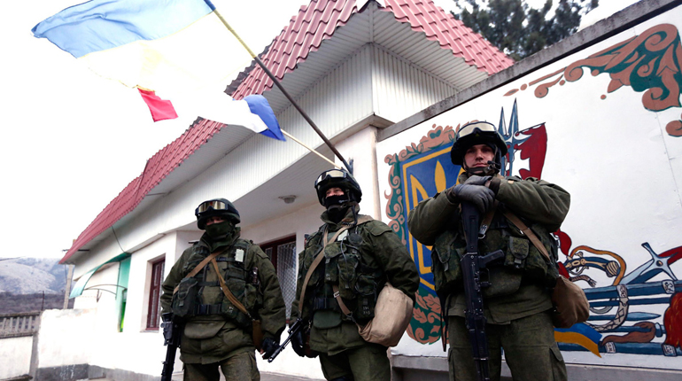 Pro-Russian forces stand guard at a Ukrainian military base. (PA)