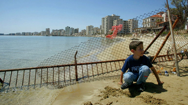 A Greek Cypriot boy in front of the Turkish-occupied zone on Cyprus. (PA)