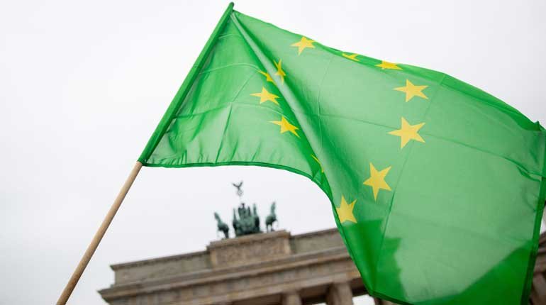 A Green EU flag in front of the Brandenburg Gate