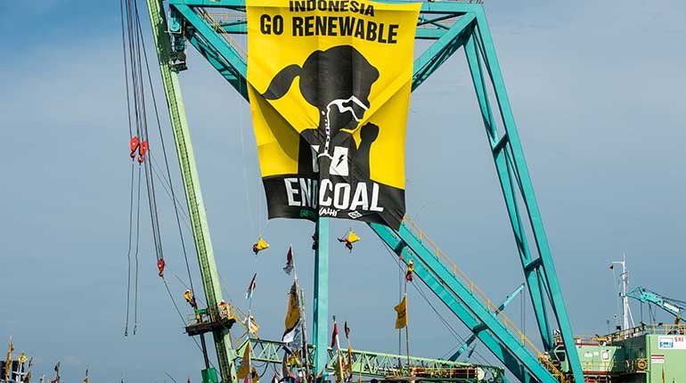 Protesters unveil a banner calling for a halt to construction of a coal-fired power plant in Central Java.